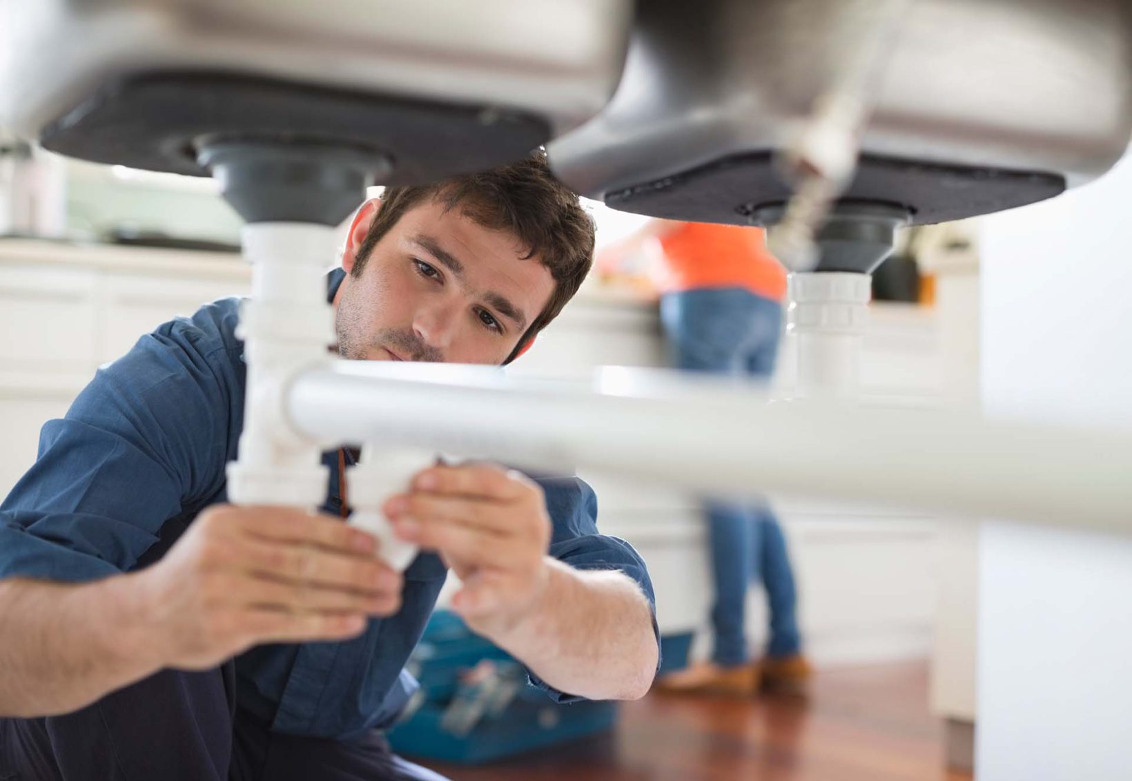A plumber repairing a sink in a property.